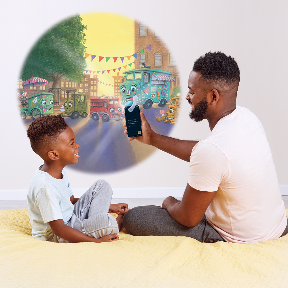 Father and Son reading Where Do Diggers Take Vacation? with the Moonlite Storytime Projector